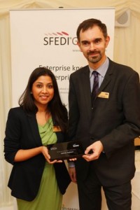  Pictured: Harsha Patel accepting the award on Adrian's behalf from Leigh Sear, CEO of SFEDI Solutions.